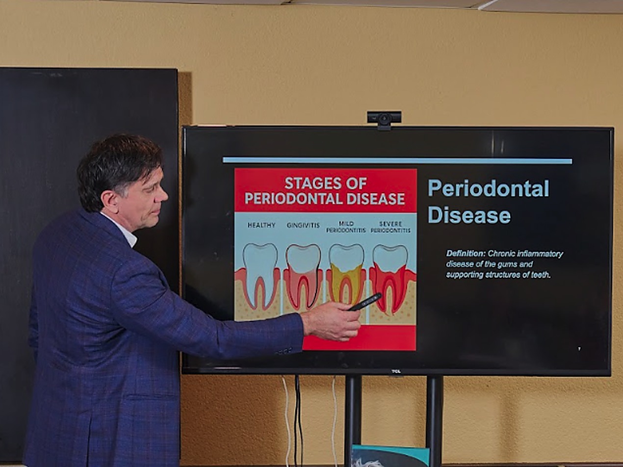 Dr. Pastouk presenting the stages of periodontal disease on screen
